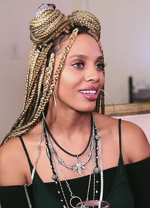 Woman with blonde box braids styled in a half-up bun